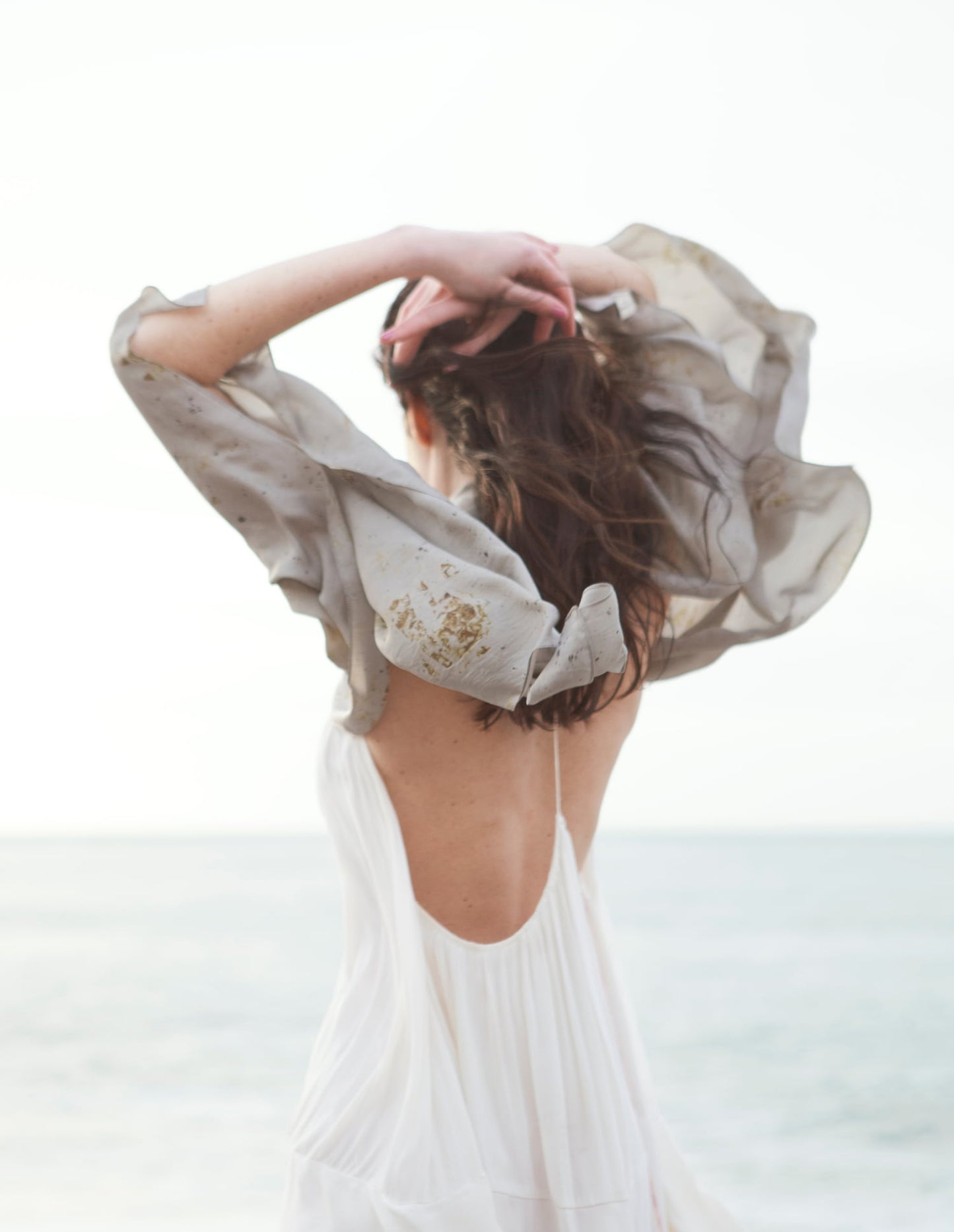 Femme portant un foulard en soie regardant la mer