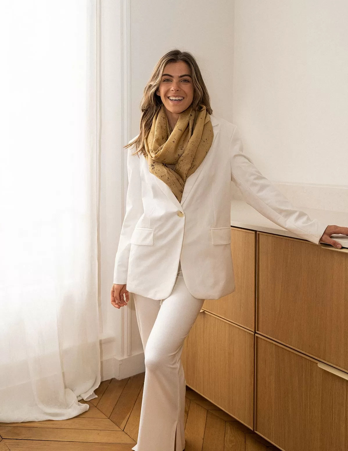 Carré en soie porté autour du cou, bouffant, au-dessus d'une veste blanche