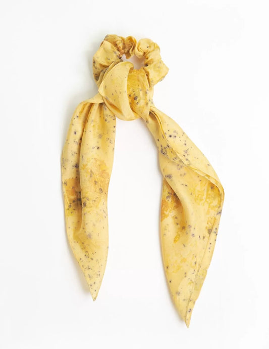 Chouchou-foulard en soie porté sur chignon devant la mer