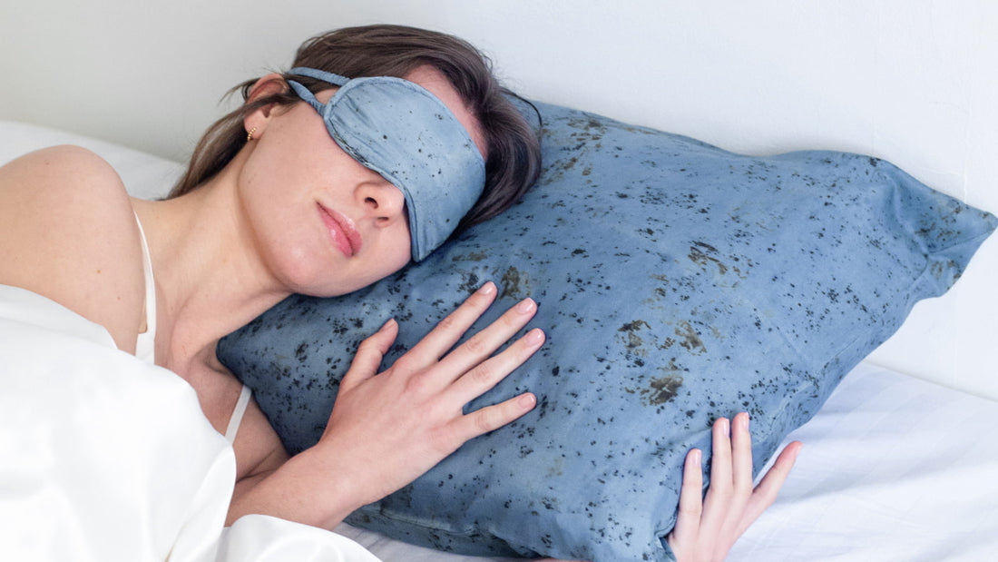 Femme dormant une sieste sur un oreiller de soie avec un masque de sieste en soie bleu