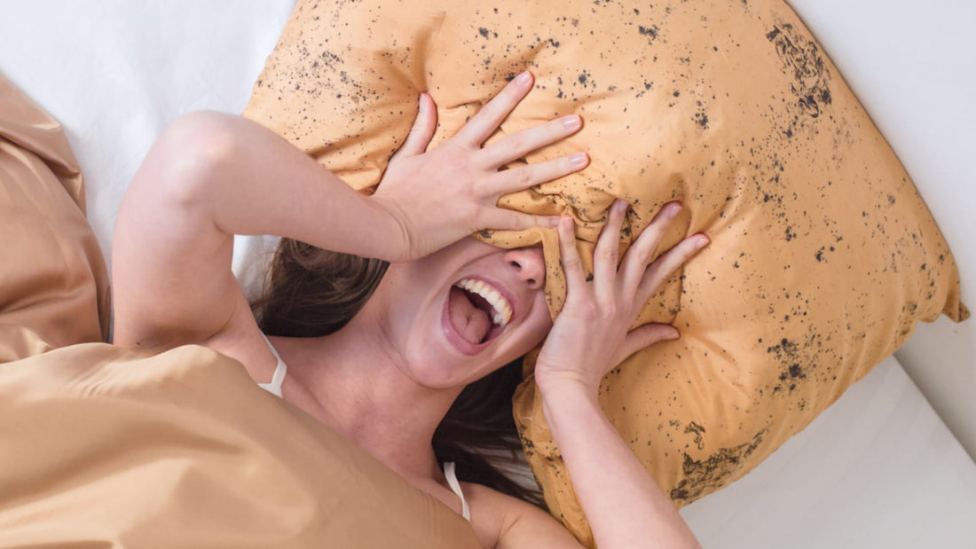 Femme riant et se cachant derrière un oreiller en soie