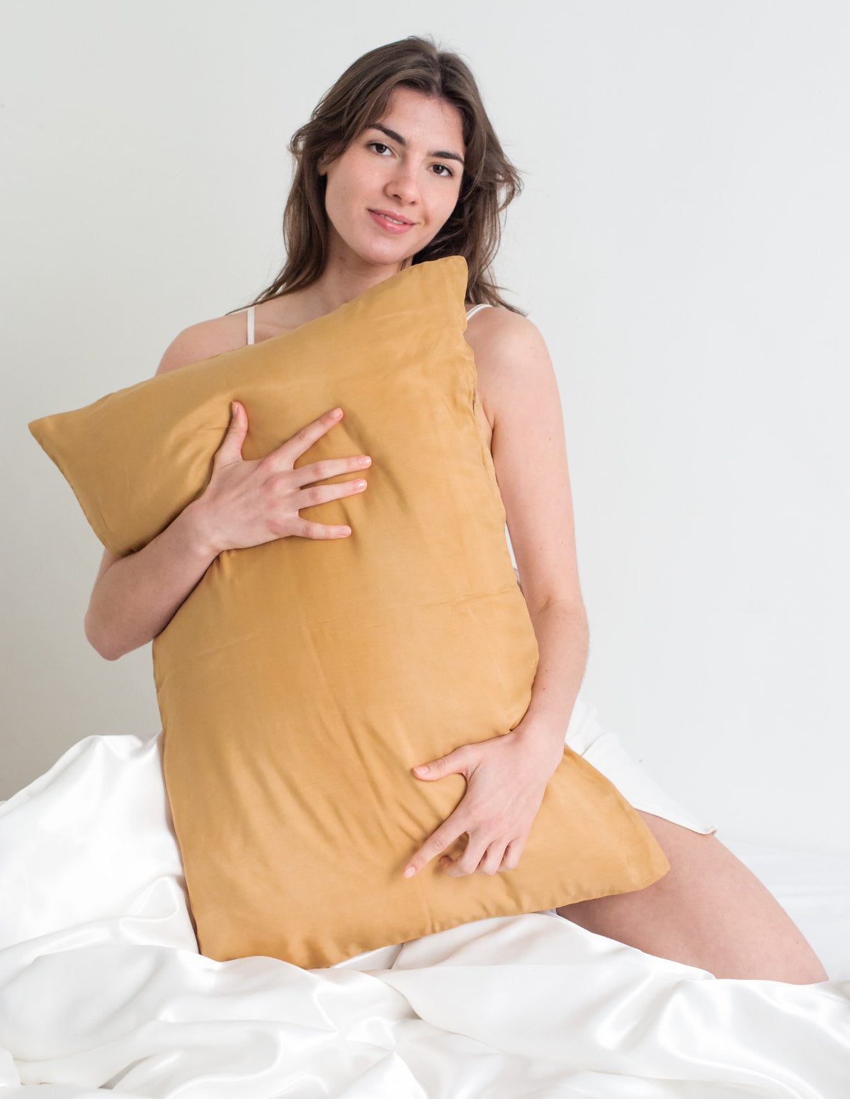 Femme enlaçant un oreiller de soie
