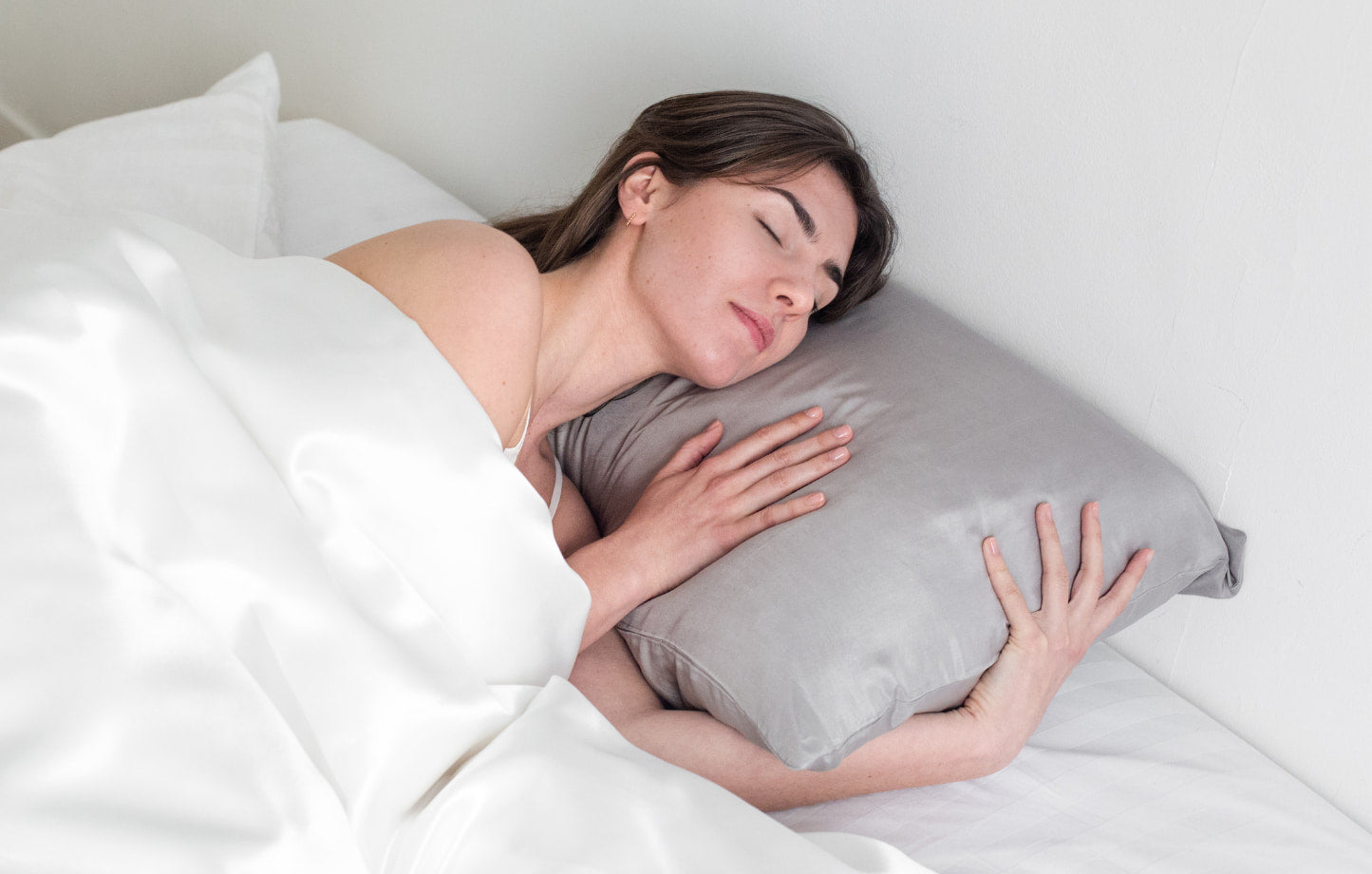 Femme dormant sur une taie d'oreiller en soie grise