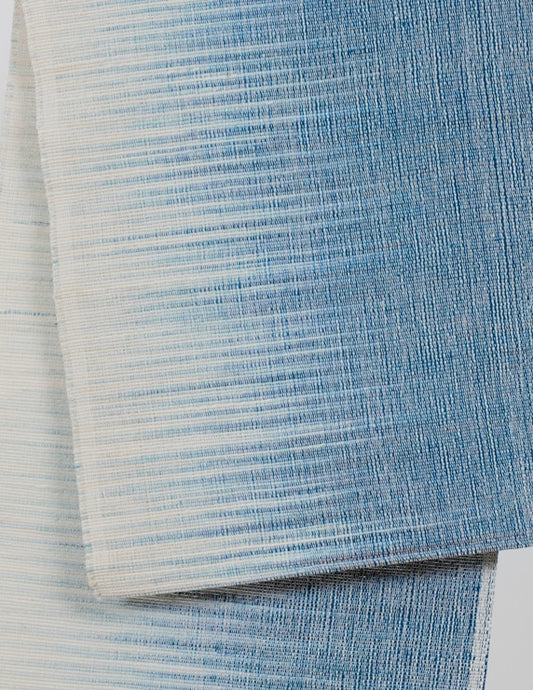 Chemin de table bicolore en lin bio suspendu sur une tringle de bambou