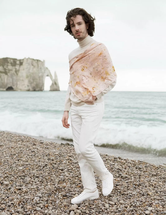 Carré de soie porté sur un pull blanc à col roulé, devant la mer